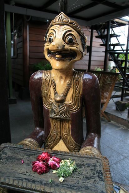 Statue et offrandes dans un café de Yogyakarta