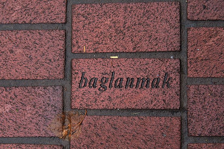 Brick engraved with the word "bağlanmak" on the sidewalk of Alexander Street in the historic Gastown neighborhood, Vancouver.