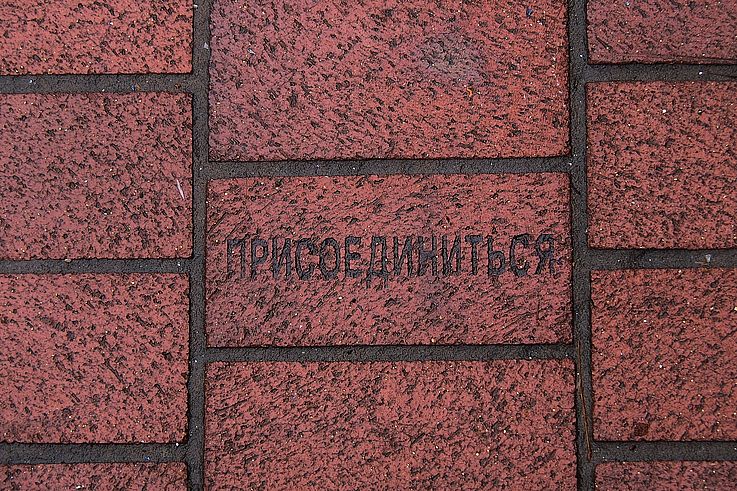 Paving stone engraved with the Cyrillic inscription "to join" in the Gastown neighborhood, Vancouver.