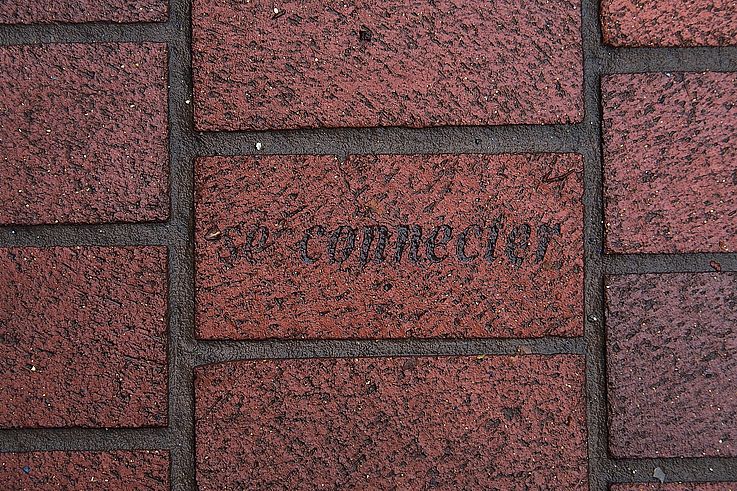 Inscription "to connect" on a wet paving stone in the Gastown neighborhood, Vancouver.