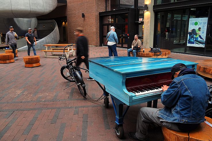 Musician playing the blue public piano in downtown Vancouver.