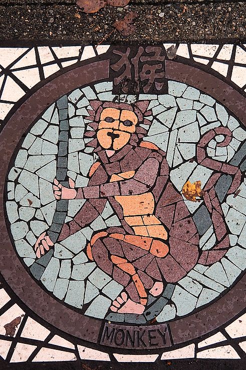 Monkey zodiac sign mosaic on a manhole cover in the Chinatown district, Vancouver.