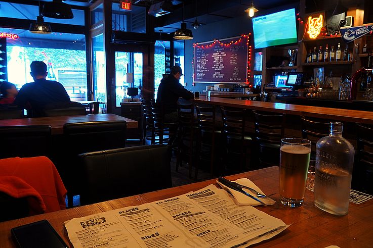 Interior of the Devil's Elbow bar on Beatty Street in Vancouver with a Canucks poster.