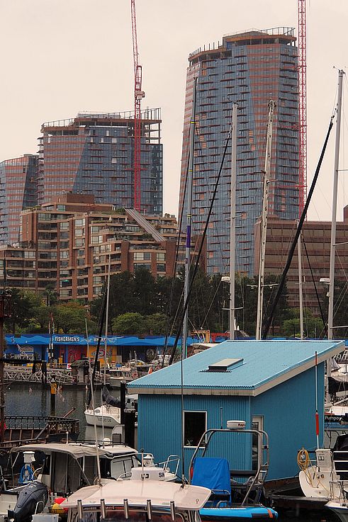 Boats at Fishermen's Wharf and skyscrapers under construction in Vancouver.