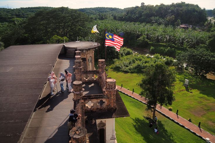 Toit de Kellie's Castle à Ipoh, avec drapeau malaisien et plantations de palmiers.
Altitude : 46 mètres