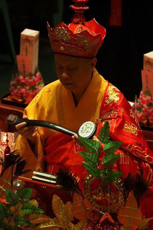 Moine tenant un sceptre ruyi au temple de la Dent de Bouddha dans le quartier de Chinatown.